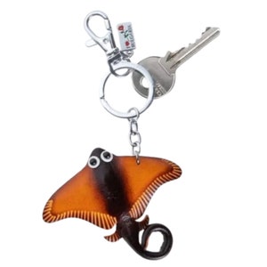 May include: A brown and black leather stingray keychain with a silver key ring and a silver clip. The keychain has a small tag that says "I love Bulgaria" with a red heart and a rose.