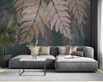 May include: A gray sectional sofa with a variety of throw pillows sits in front of a wall with a large-scale fern print wallpaper. The wallpaper is a dark teal color with brown ferns.