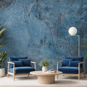 Könnte beinhalten: Ein Innenraum mit einer strukturierten blauen Wandtapete mit dunklen, verwitterten Mustern. Zwei blau gepolsterte Sessel mit hellem Holzrahmen stehen auf einem weißen Teppich. Ein runder Couchtisch aus hellem Holz trägt eine kleine Pflanze.