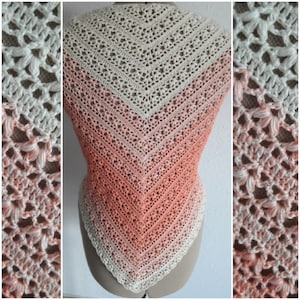 Könnte beinhalten: Ein handgefertigter Häkelschal in Dreiecksform. Der Schal hat eine Farbverlauf, der von Creme zu Pfirsich übergeht. Das offene Design verleiht dem Kleidungsstück eine zarte und luftige Qualität. Der Schal wird auf einer Schaufensterpuppe präsentiert.