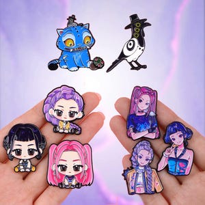 May include: A selection of enamel pins with cartoon and anime-style designs. The pins depict a blue cat, a black and white bird, and several female characters with different hairstyles and clothing. These decorative pins are suitable for attaching to clothing or accessories.