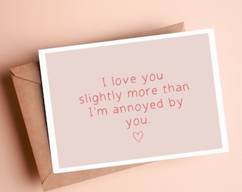 May include: A light pink card with a white border and the text "I love you slightly more than I'm annoyed by you." with a small pink heart.