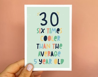 May include: A birthday greeting card with the number "30" in navy blue, and the text "SIX TIMES COOLER THAN THE AVERAGE 5 YEAR OLD" in various colors. The card is held by a hand against a pink background.