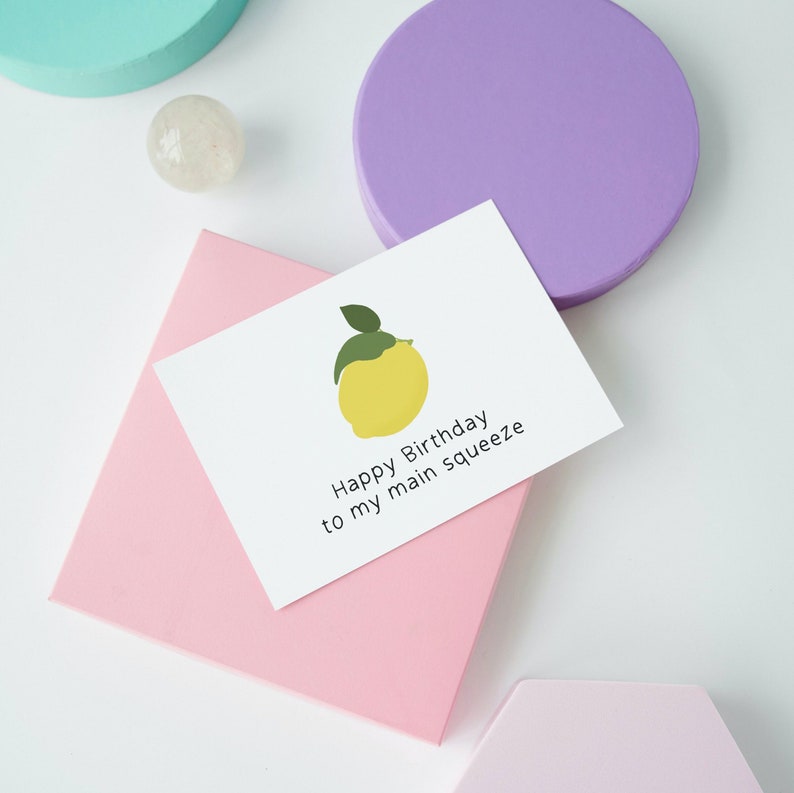 May include: A white card with a yellow lemon illustration and the text "Happy Birthday to my main squeeze".