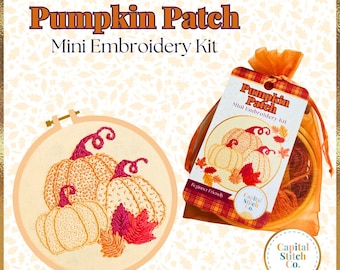 Puede incluir: Un kit de bordado en miniatura con un diseño de campo de calabazas. El kit incluye un aro, hilo de bordar y una aguja. El kit está empaquetado en una bolsa de plástico transparente con una etiqueta que dice "Pumpkin Patch Mini Embroidery Kit".