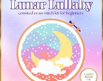 Puede incluir: Un kit de punto de cruz contado para principiantes, titulado "The Lunar Lullaby". El diseño presenta una luna creciente pixelada, nubes y estrellas en colores pastel, dentro de un bastidor de bordado. El kit es de Capital Stitch Co.