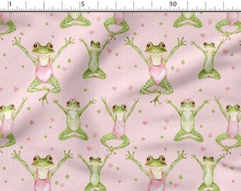 May include: A pink fabric with a repeating pattern of green frogs wearing pink leotards and doing yoga poses. The background is a light pink with small green and pink dots.