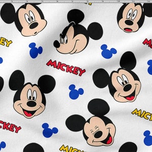 May include: White fabric with a repeating pattern of Mickey Mouse faces in different expressions. The word "MICKEY" is printed in red and yellow, alongside blue Mickey Mouse head silhouettes. Suitable for children's clothing and accessories.