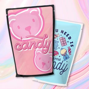 Puede incluir: Dos bolsas rosas y azules con un tema de dulces. La bolsa rosa tiene un oso rosa con la palabra "candy" en letras rosas. La bolsa azul tiene el texto "You need is candy" con una m&aacute;quina de chicles, una dona y una barra de chocolate.