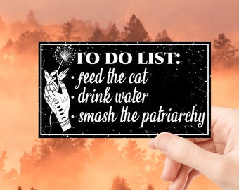 Puede incluir: Una tarjeta de lista de tareas pendientes en blanco y negro con una mano sosteniendo un diente de león. El texto dice "TO DO LIST: feed the cat, drink water, smash the patriarchy."