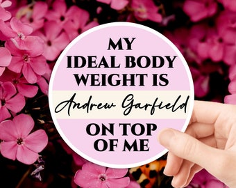 May include: A pink and white round sticker with the text "My ideal body weight is Andrew Garfield on top of me".