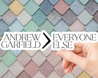 May include: A white sticker with black text that reads "Andrew Garfield > Everyone Else" on a colorful background of pastel blue, green, pink, and yellow diamond-shaped tiles.