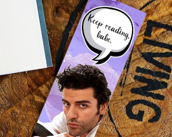 May include: A purple and white bookmark with a picture of a man and a speech bubble that says "Keep reading, babe."