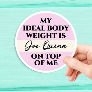 May include: A pink and white round sticker with the text "My ideal body weight is Joe Quinn on top of me".
