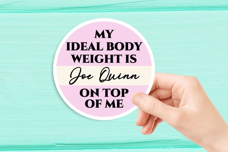 May include: A pink and white round sticker with the text "My ideal body weight is Joe Quinn on top of me".