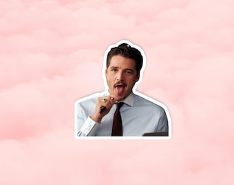 May include: A sticker featuring a man with dark hair, wearing a light blue dress shirt and a brown tie. He is sticking out his tongue while holding a pen. The background is a pink watercolor wash.