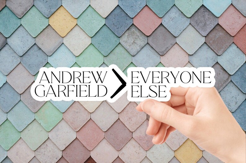 May include: A white sticker with black text that reads "Andrew Garfield > Everyone Else" on a colorful background of pastel blue, green, pink, and yellow diamond-shaped tiles.