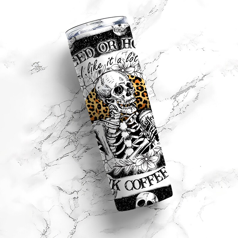 May include: A black and white stainless steel tumbler with a skeleton holding a coffee cup. The tumbler has a leopard print design and the text "Iced or Hot I like it a lot Black Coffee".
