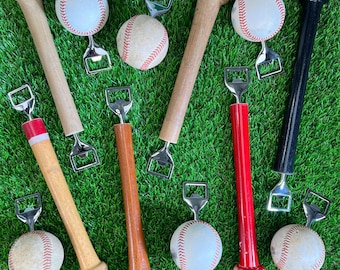 May include: Nine baseball bats with bottle openers attached to the ends. The bats are made of wood and have a natural finish. The bottle openers are made of metal and have a silver finish. There are also nine baseballs in the image, each with a white background and red stitching.