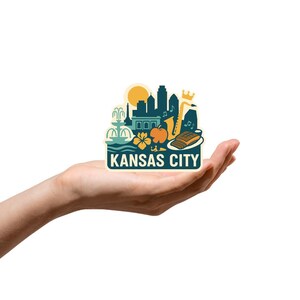 Puede incluir: Una colorida pegatina con un dise&ntilde;o de Kansas City. La pegatina incluye un horizonte, una fuente, un saxof&oacute;n y el texto "KANSAS CITY". La pegatina se sostiene en una mano sobre un fondo blanco.