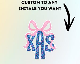 May include: A sticker featuring the initials "KAS" in a blue floral pattern, accented with a pink bow. The text "CUSTOM TO ANY INITIALS YOU WANT" is displayed above the sticker, with a black arrow pointing towards it.