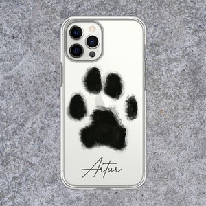 May include: Clear phone case featuring a large, black paw print design. The name "Artur" is written in a cursive font below the paw print. The case is designed to fit a smartphone.