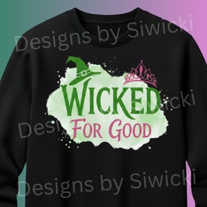 Può includere: Felpa nera con un cappello da strega verde e le parole "WICKED FOR GOOD" in verde e rosa. Una corona rosa è sopra la parola "WICKED". Il testo "Designs by Siwicki" è stampato sopra e sotto.