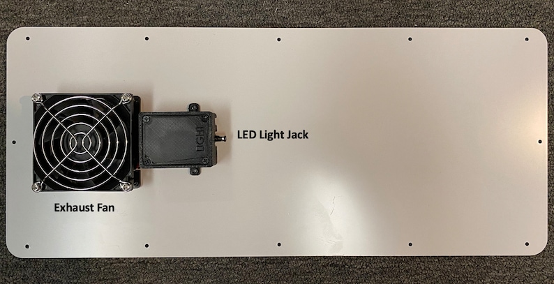 May include: A white metal panel with a black exhaust fan and a black LED light jack. The text "LED Light Jack" and "Exhaust Fan" are printed on the panel.