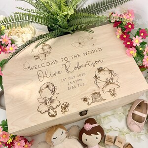 May include: A wooden keepsake box engraved with a design of fairies and butterflies. The box is personalised with the name "Olive Robertson" and the date "1st July 2020". The inscription also includes the time "15:53PM" and the baby's weight "3lbs 7oz".