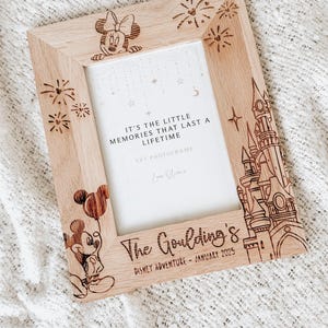 May include: A wooden photo frame featuring a Mickey Mouse and Minnie Mouse design. The frame is engraved with the text "It's the little memories that last a lifetime", "5x7 Photoframe", "Love Alice", "The Goulding's", "Disney Adventure - January 2025".
