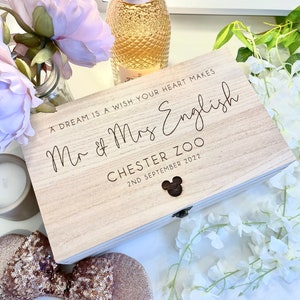 May include: A wooden box with a Mickey Mouse design on the front. The box is engraved with the text "A dream is a wish your heart makes Mr & Mrs English Chester Zoo 2nd September 2022".