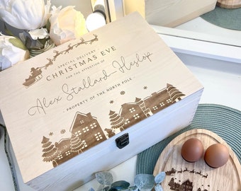 May include: A wooden box with a Christmas Eve design, personalized with the name "Alex Stallard-Heslop". The box is decorated with a snowy village scene and the text "Special Delivery for the Attention of... Property of the North Pole".