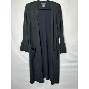 May include: A charcoal gray long cardigan with long sleeves and two front pockets. The sleeves have a flared, bell-like shape. The cardigan is hanging on a black hanger against a white background. The brand name is visible at the top.