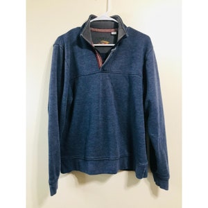 May include: A blue long-sleeved pullover sweater with a quarter zip closure and a small logo on the front.