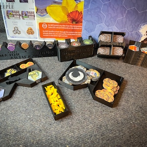 May include: A set of black plastic organisers for a board game. The organisers are labelled "Major Artifacts", "Minor Artifacts", "Worker Tokens", "Gates", and "Crates".