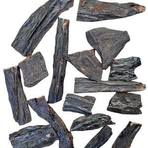 May include: A collection of 13 dark brown, dried, and irregularly shaped pieces of beef jerky.