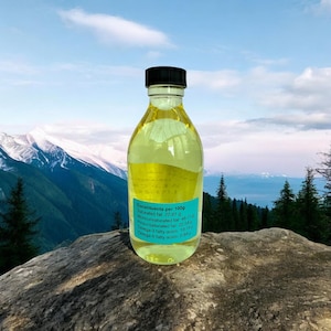 Puede incluir: Una botella de vidrio transparente con una tapa negra llena de un l&iacute;quido amarillo. La botella est&aacute; etiquetada con el texto "Constituents per 100g", "Sat fat: 22.61 g", "Monounsaturated fat: 48.71 g", "Polyunsaturated fat: 22.54 g", "Omega-3 fatty acids: 19.74 g" y "Omega-6 fatty acids: 0.94 g".