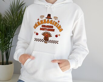 May include: White hooded sweatshirt with a Thanksgiving-themed graphic. The design features the text "THANKSGIVING CALORIES DON'T COUNT" in orange, a turkey, and other festive elements. The sweatshirt has a front pocket and a drawstring hood.