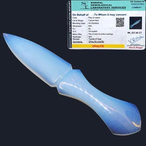 Puede incluir: Un cuchillo de opalita azul claro, de 227,46 quilates, con una punta puntiaguda y un mango redondeado. El cuchillo es un ejemplo típico de opalita.