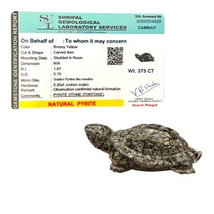 May include: A brassy yellow pyrite stone tortoise figurine. The carved item is studded in resin and weighs 375 CT. The gemstone identification report is from Shrifal Gemological Laboratory Services.