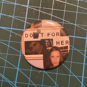Puede incluir: Un botón redondo con el texto "DO IT FOR HER" en letras mayúsculas negras. El botón presenta un collage de imágenes, incluyendo retratos de mujeres. El botón tiene un acabado brillante.