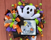 Trick-or-treat large ghost wreath, orange, black and white. Festive display and friendly ghost adornment, perfect for front door!