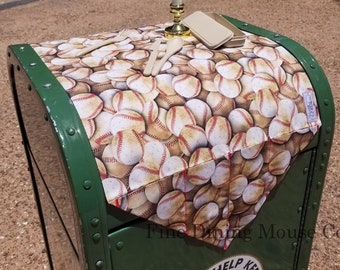 May include: A green metal trash can with a baseball-themed tablecloth on top. The tablecloth has a white candle in a gold candlestick and a wooden spoon and fork. The trash can has a sticker that says "Please Help Keep Our City Clean".