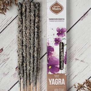 Puede incluir: Un paquete de inciensos con una etiqueta blanca y morada. La etiqueta dice "Sagrada Madre" y "YAGRA VIOLETAS LAVANDA". La etiqueta también dice "Incienso a Base de Frutas".