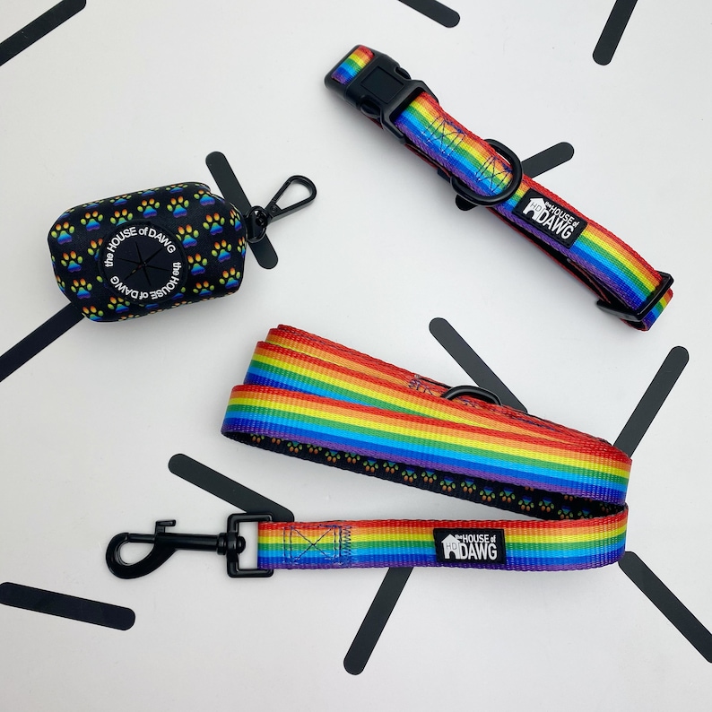May include: A rainbow dog leash and collar set with black paw prints and the text "The House of Dawg".