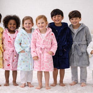 May include: A group of children wearing colorful hooded bathrobes. The robes are in various colors, including yellow with dinosaur prints, pink with cherries, light blue with polka dots, and pink with a giraffe pattern. Other robes are navy blue, gray, and white.