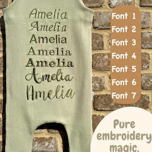 May include: Sage green baby romper with the name "Amelia" embroidered in seven different fonts. The ribbed fabric onesie is displayed against a brick wall. Text on the right side reads "Pure embroidery magic."