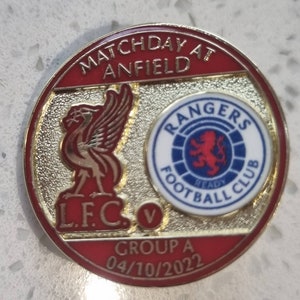 Könnte beinhalten: Eine rot-weiß-blaue Anstecknadel mit dem Text "Matchday at Anfield" und "L.F.C. v Rangers Football Club" mit dem Datum "04/10/2022" und "Group A".