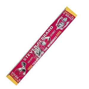 May include: A maroon scarf with yellow fringe featuring the text "STEVEN GERRARD" and "STEVIE G THE LEGEND." The scarf includes images of a soccer player and the text "504 APPS, 120 GOALS, 1998 THANKS FOR THE MEMORIES 2015."