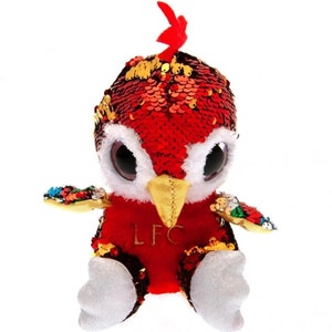 May include: Red and gold plush toy with large eyes and a sequin covered body. The toy has a beak and wings and is wearing a red shirt with the letters "LFC" on the front.